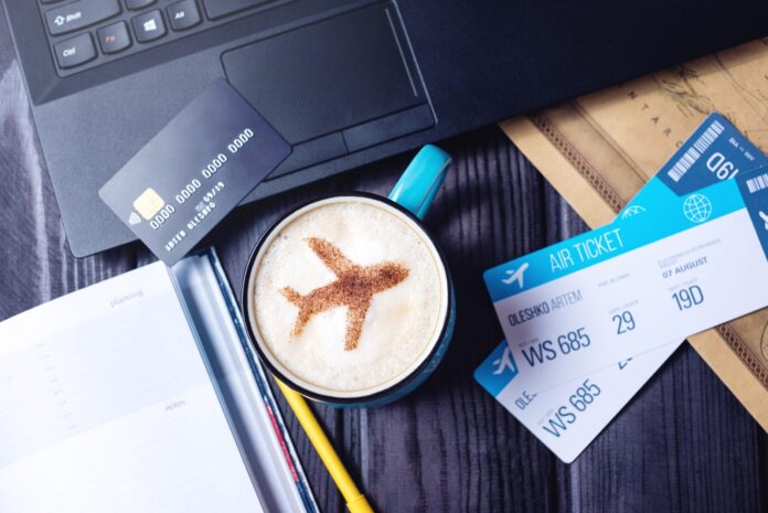 Laptop,,Plane,Tickets,,Coffee,,Cappuccino,And,Credit,Card,Lies,On